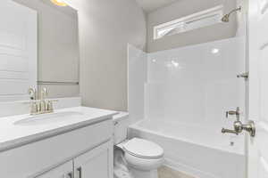 Full bathroom featuring vanity, toilet, and  shower combination