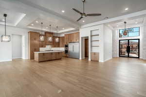 Kitchen with a raised ceiling, stainless steel appliances, and pendant lighting