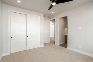 Unfurnished bedroom featuring a closet, light colored carpet, and ceiling fan