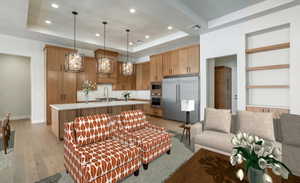 Living room featuring a raised ceiling, light hardwood / wood-style floors, and sink