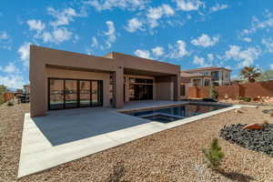 Rear view of property featuring a patio area and a pool with hot tub