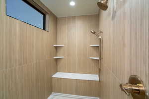 Bathroom featuring a shower and a textured ceiling