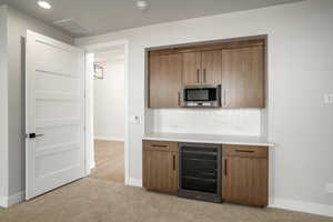 Kitchen with light colored carpet and wine cooler