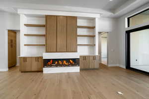 Unfurnished living room with light hardwood / wood-style flooring, a high end fireplace, and built in features