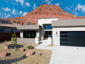 View of front of home with a mountain view and a garage