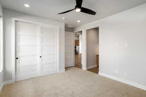 Unfurnished bedroom with light carpet, ceiling fan, and a closet