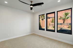 Carpeted empty room featuring ceiling fan