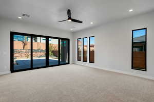 Carpeted spare room featuring ceiling fan