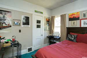 Bedroom featuring carpet, a textured ceiling, and a textured wall