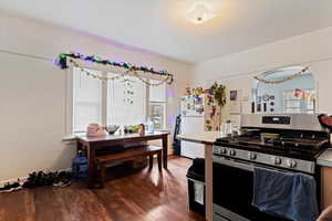 Kitchen featuring hardwood / wood-style flooring, stainless steel gas range, and white fridge