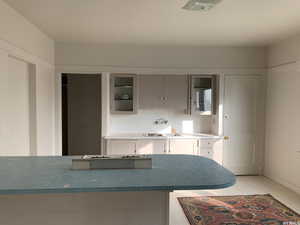 Kitchen with light tile patterned flooring and glass insert cabinets