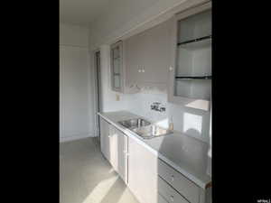 Kitchen with light countertops, light floors, and glass insert cabinets
