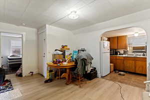 Kitchen featuring lofted ceiling, sink, light wood-type flooring, and white refrigerator