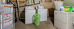 Laundry area with gas water heater and washer and clothes dryer