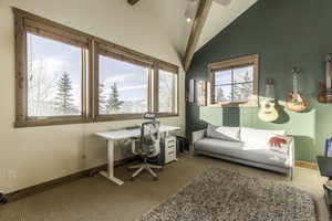 Office space with lofted ceiling with beams and carpet floors