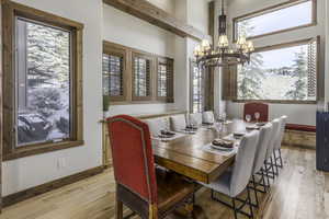 Dining area with light wood-type flooring and an inviting chandelier