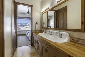 Bathroom featuring tile patterned floors, vanity, and ceiling fan