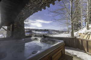 Snow covered patio with a hot tub