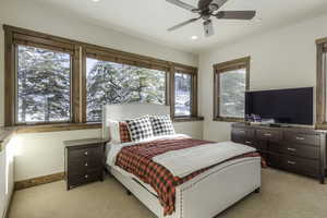 Bedroom with ceiling fan and light colored carpet