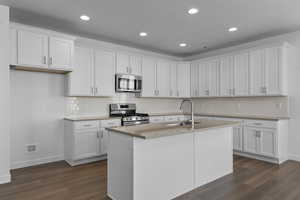 Kitchen featuring sink, stainless steel appliances, and white cabinetry