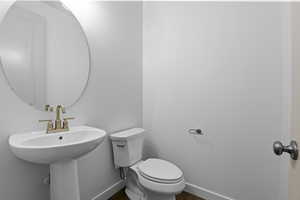 Bathroom with sink, toilet, and hardwood / wood-style floors