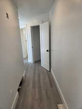 Hall with wood finished floors and baseboards