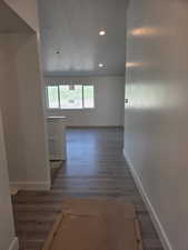 Corridor featuring baseboards, wood finished floors, and recessed lighting
