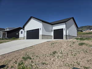 View of front of property featuring an attached garage and driveway