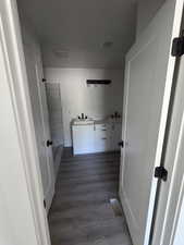 Bathroom featuring double vanity, a tile shower, and wood finished floors