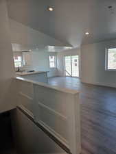 Kitchen with white cabinetry, wood finished floors, recessed lighting, baseboards, and open floor plan