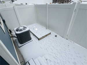 Snow covered patio featuring central air condition unit