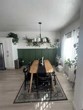 Dining room with light hardwood / wood-style floors and a textured ceiling