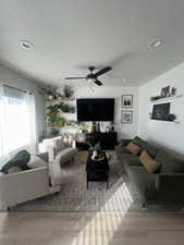 Living room featuring ceiling fan, a textured ceiling, and hardwood / wood-style floors