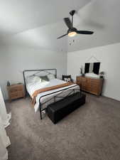 Carpeted bedroom with vaulted ceiling, ceiling fan, and a textured ceiling