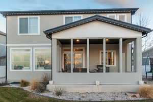 Rear view of house featuring a sunroom