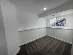 Basement featuring visible vents, carpet flooring, a textured ceiling, and baseboards