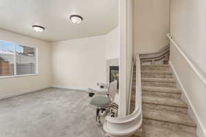 Stairs featuring carpet floors and a high end fireplace