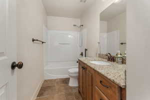 Full bathroom featuring bathtub / shower combination, toilet, and vanity