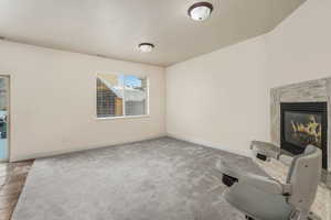 Unfurnished room with light carpet and a fireplace