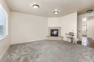 Unfurnished living room with a premium fireplace and carpet floors