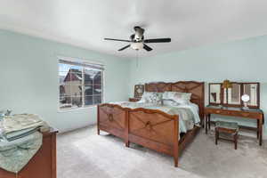 Bedroom with ceiling fan and light colored carpet