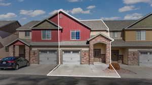 View of property featuring driveway, an attached garage, board and batten siding, and roof with shingles