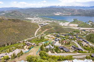 Aerial view of property and surrounding area featuring a water and mountain view and nearby suburban area