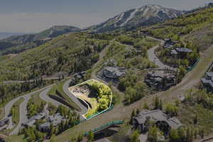 Aerial view of property and surrounding area featuring a mountain backdrop and property parcel outlined