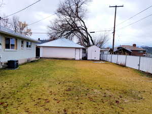 View of yard featuring central air condition unit and a shed