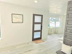 Foyer entrance featuring light wood-type flooring and a textured ceiling