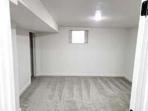 5th bedroom with a textured ceiling and light colored carpet