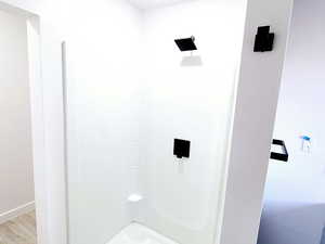 Mater bathroom featuring hardwood / wood-style flooring and a  walk in shower