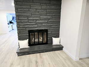 Room details with hardwood / wood-style floors and a stone fireplace