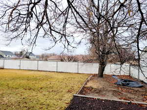 View of fully fenced yard and large garden spot